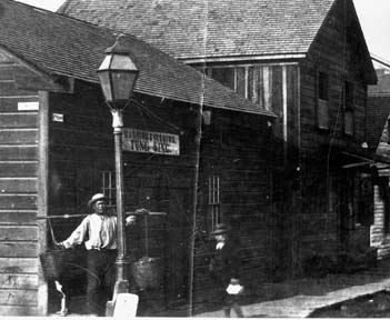 Chinese man holding buckets in front of building. A slice of Eureka's Chinatown in 1885. The sign in the background advertises Washing and Ironing ...